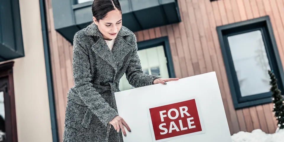 BLOG IMAGE - Woman with For Sale Sign in winter